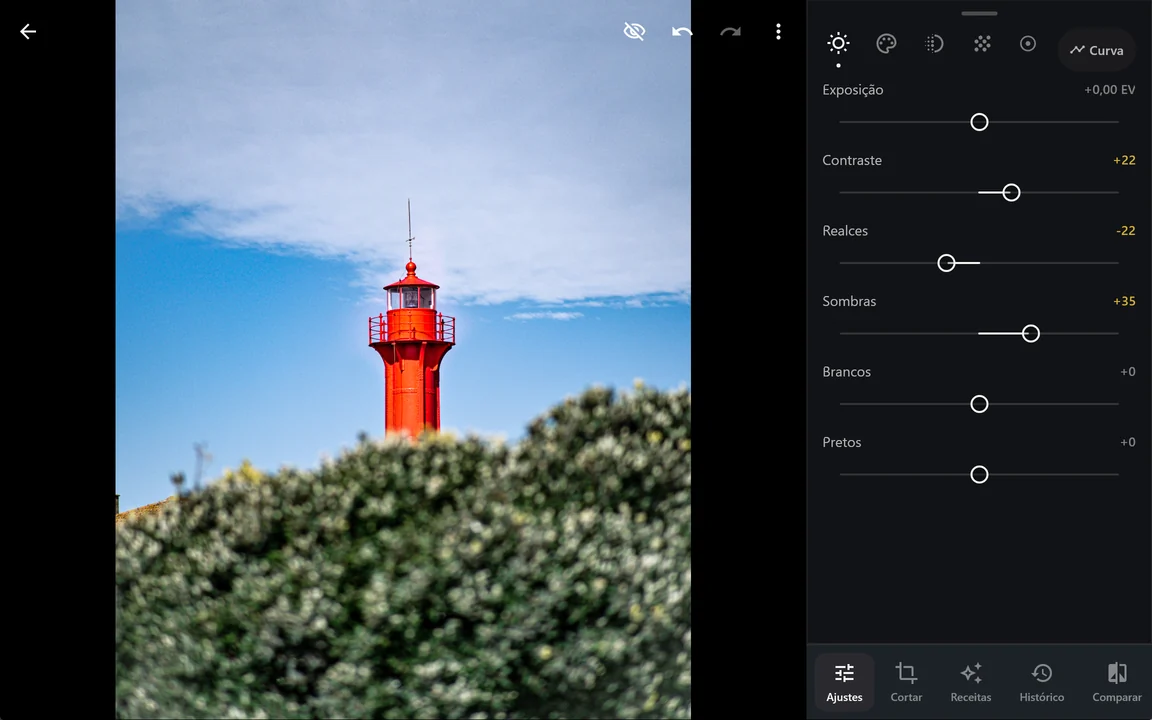 O editor em ecrã largo: o farol vermelho à esquerda e, numa coluna à direita, os ajustes de luz com Contraste +22, Realces -22 e Sombras +35.